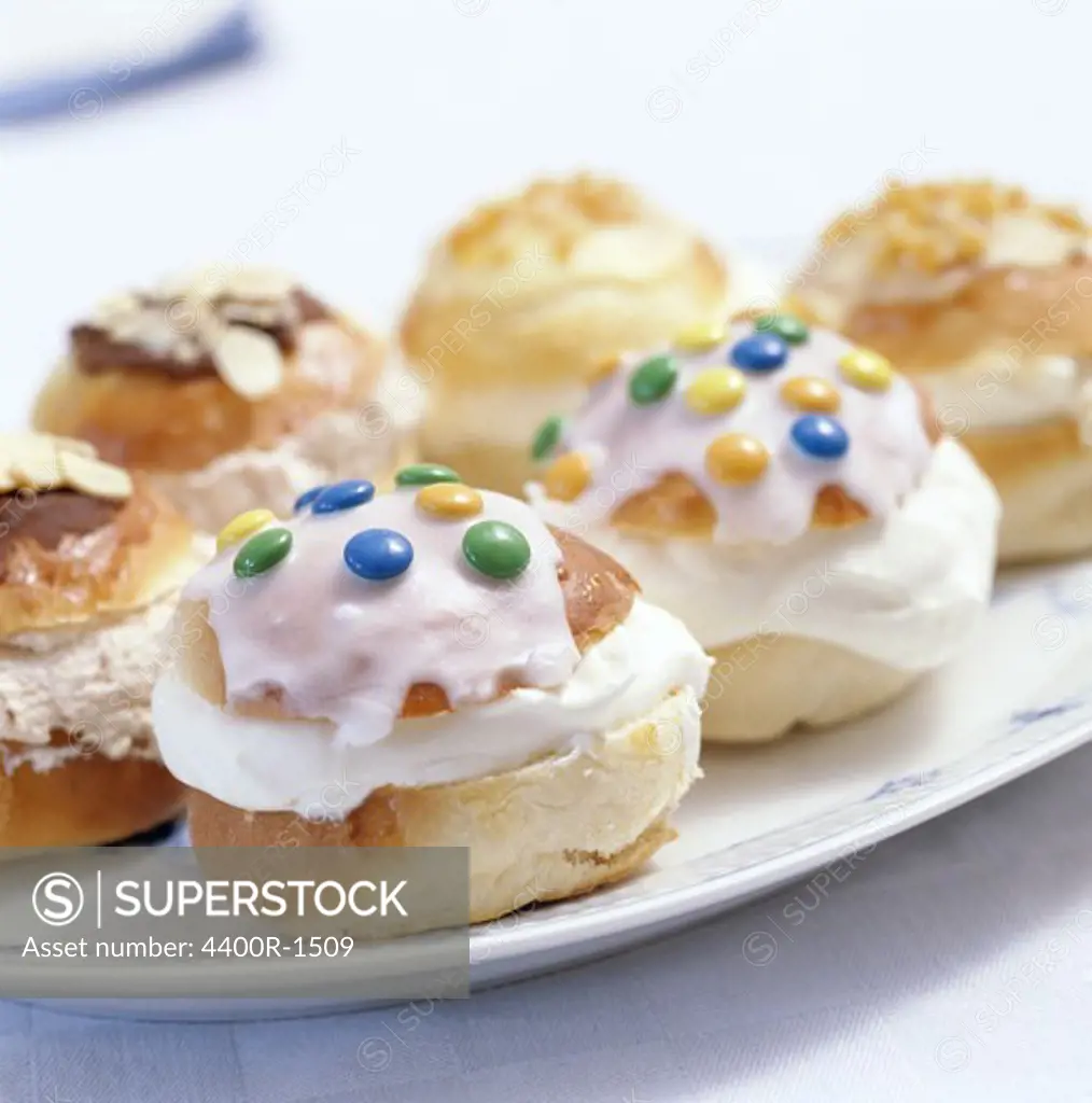 Cream buns with almond paste on plates, Sweden.