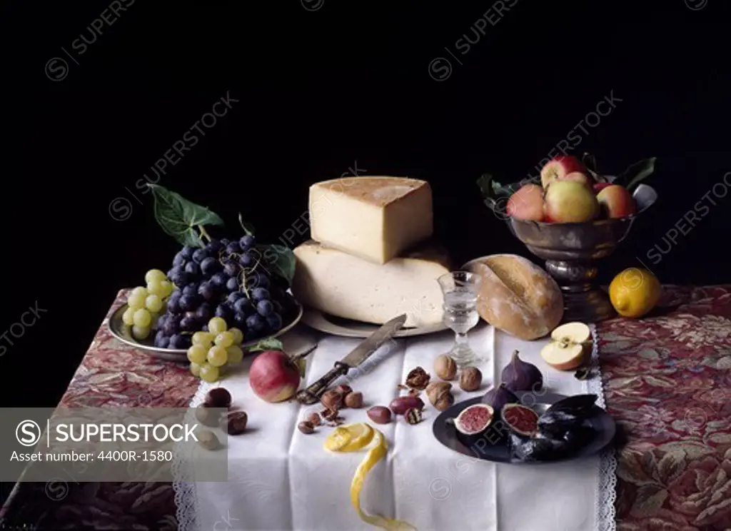 Still life with bread, cheese and fruit.
