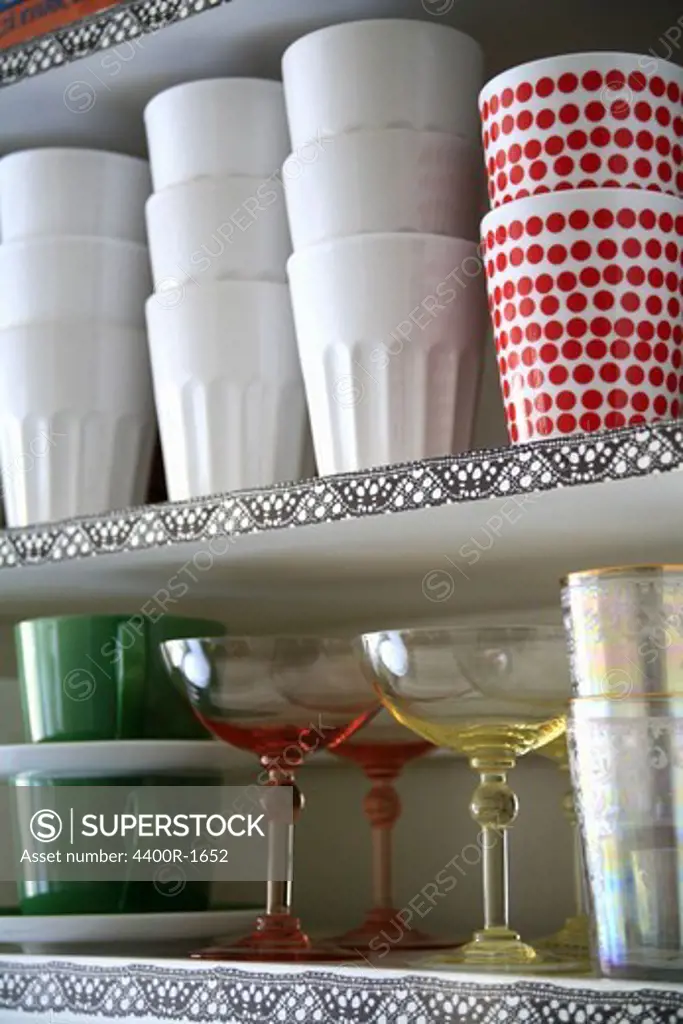 Cups on a shelf in a kitchen.