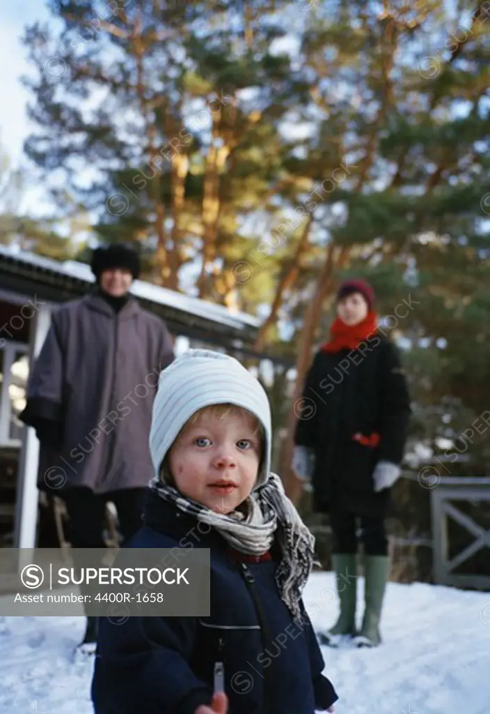 A little boy with his grandmother and mother in the snow, Sweden.