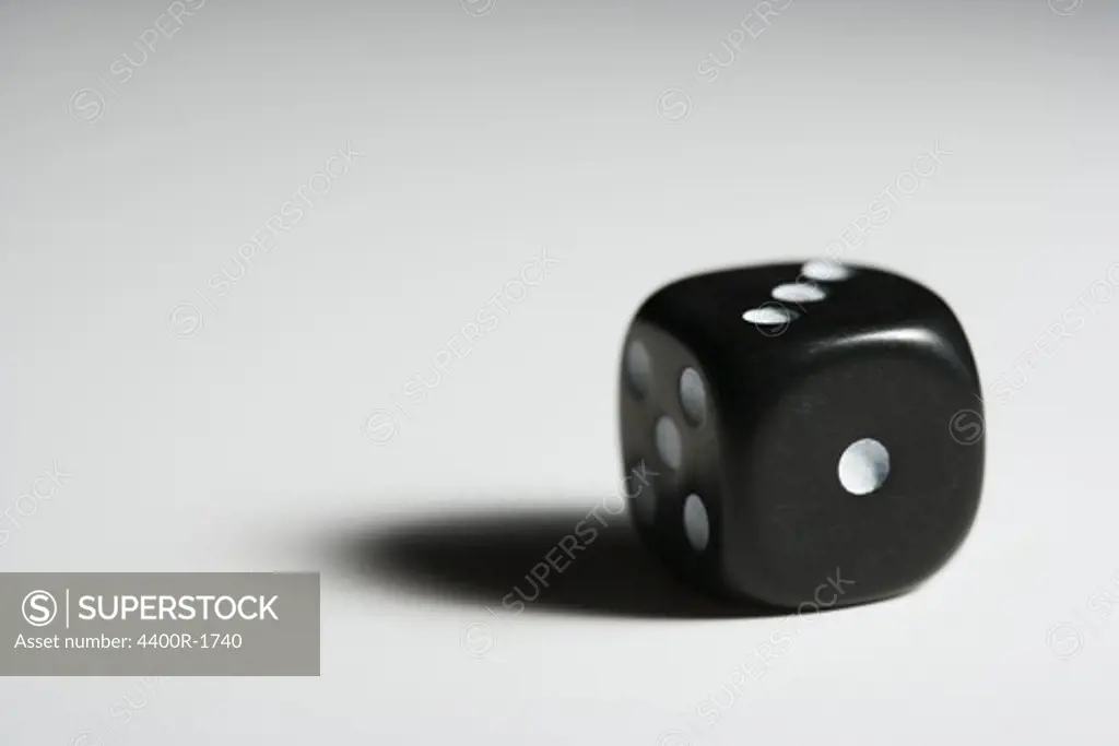 A black dice against white background.