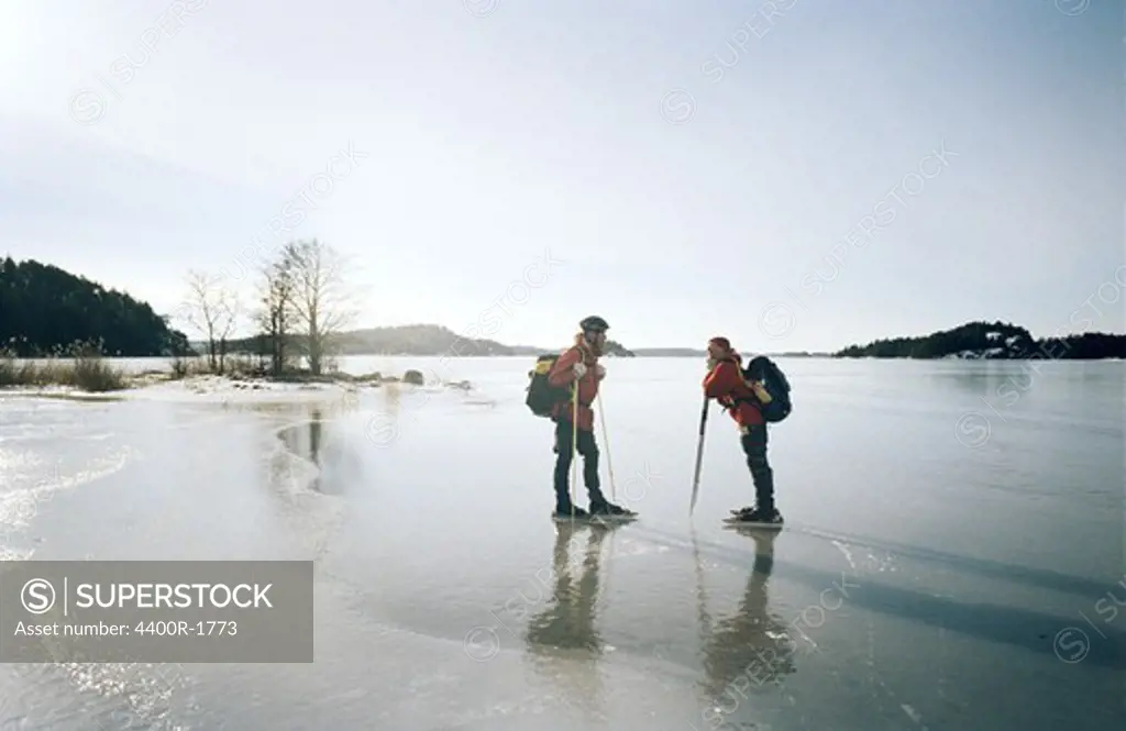 Two people long-distance skating, Stockholm archipelago, Sweden.