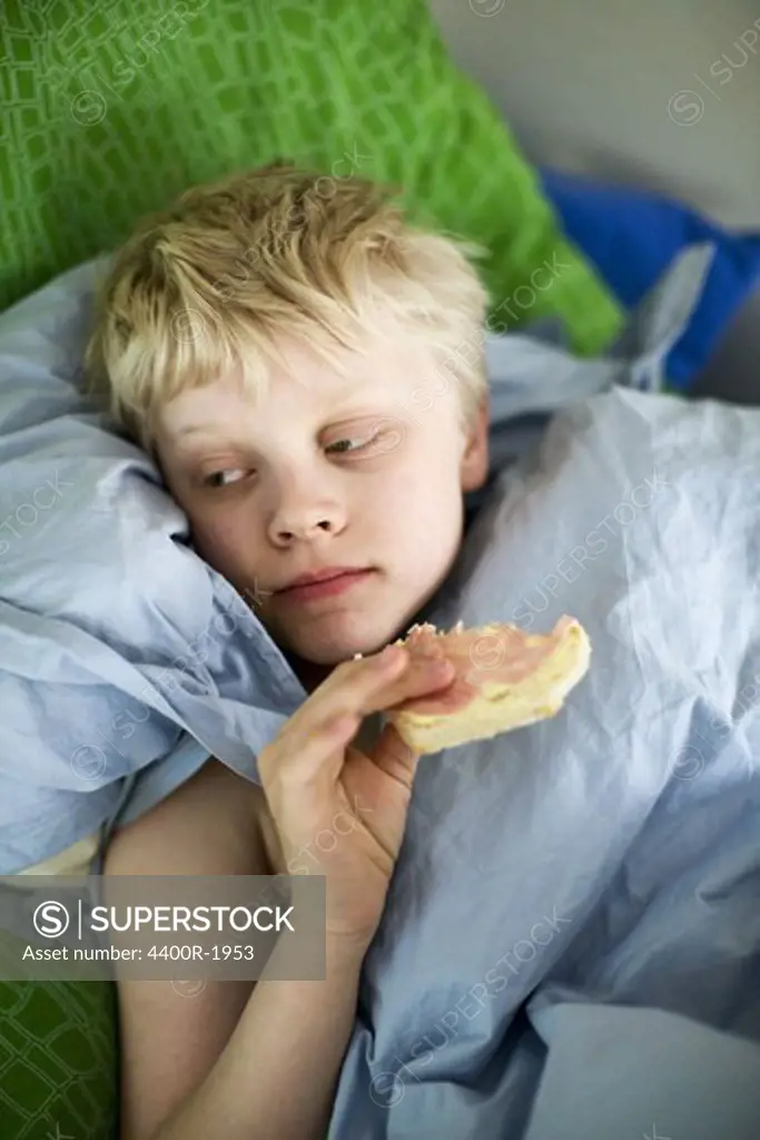 A boy having breakfast in the bed.