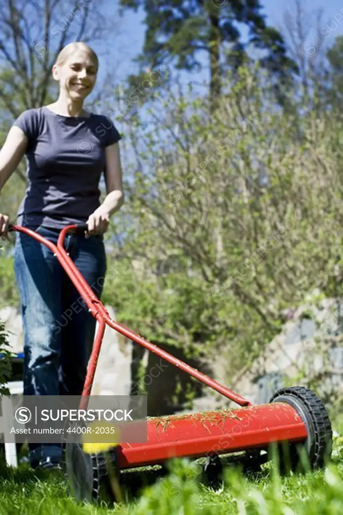 A woman moving the lawn, Sweden.