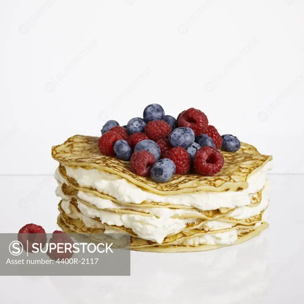 Pancakes with whipped cream and berries, studio shot