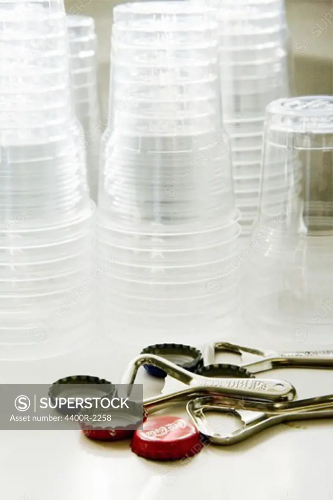 Plastic cups, bottle tops and bottle-opener.