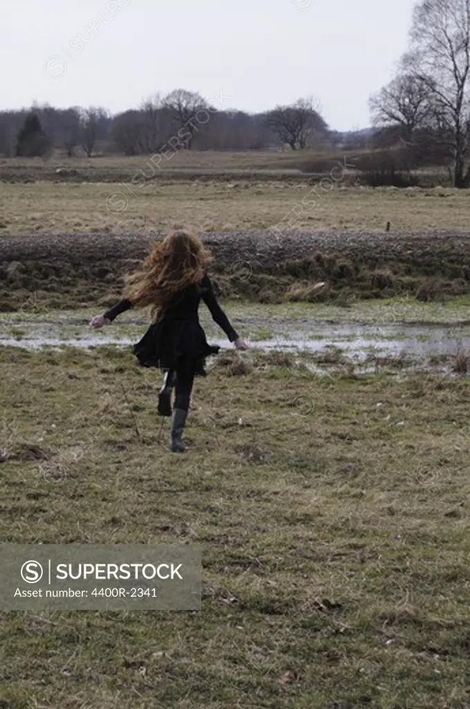 A young woman running on a field, Sweden.