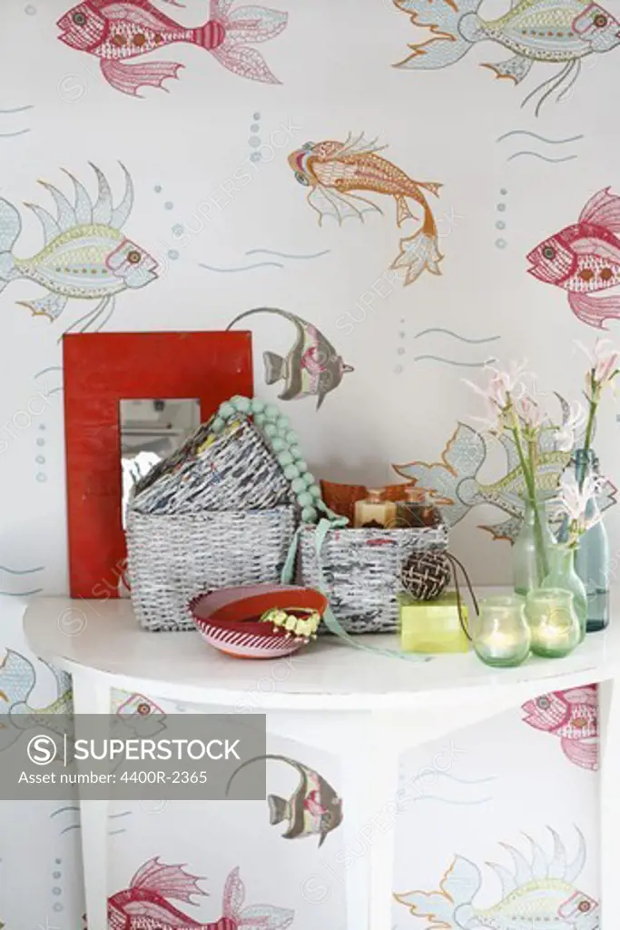 A fish wallpaper behind a side board.