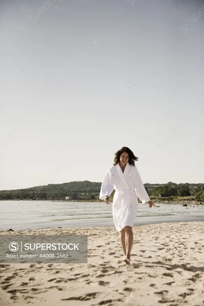 Woman on a beach dressed in a bathrobe, Sweden.