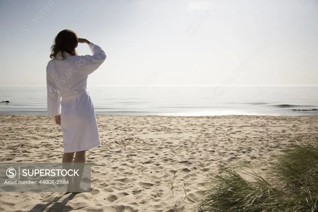 Woman on a beach dressed in a bathrobe, Sweden.