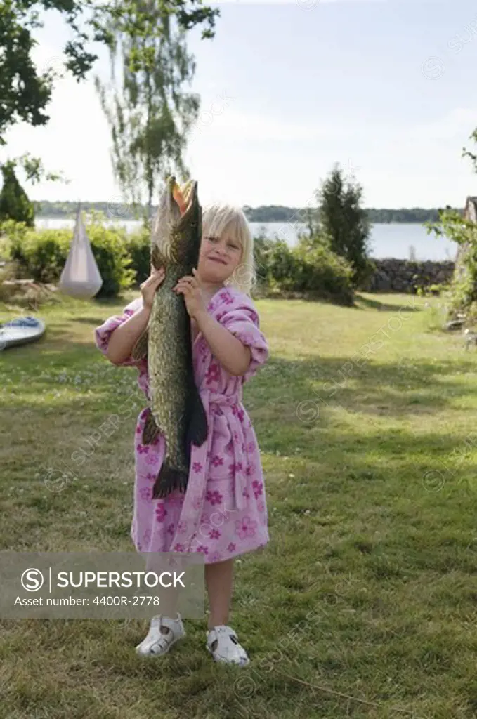 Girl holding a big pike, Sweden.