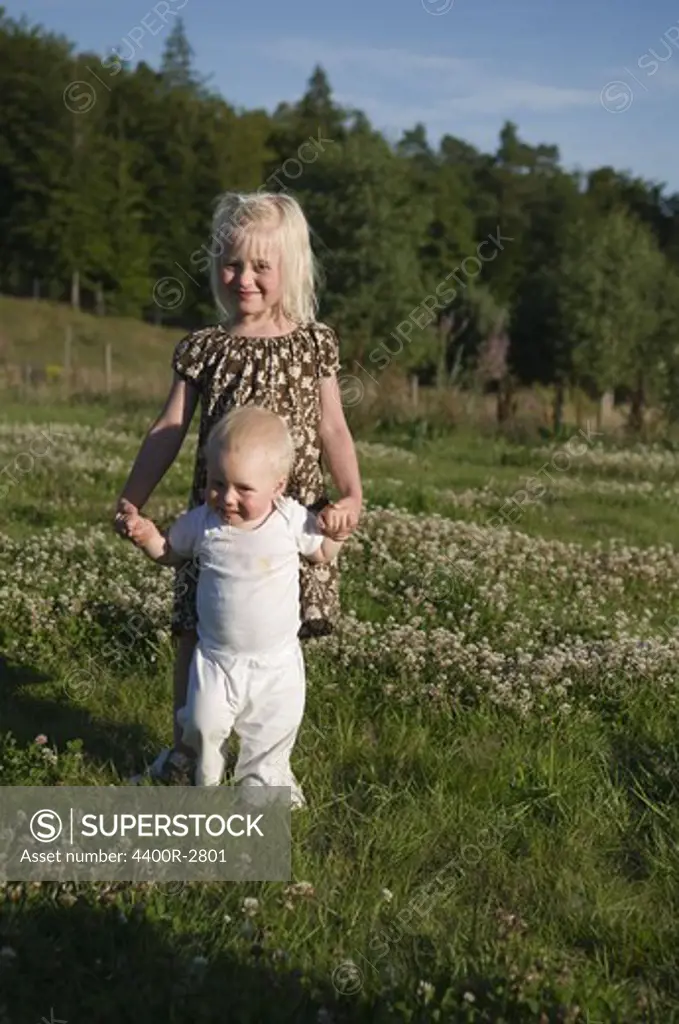 A sister and brother on a field, Sweden.
