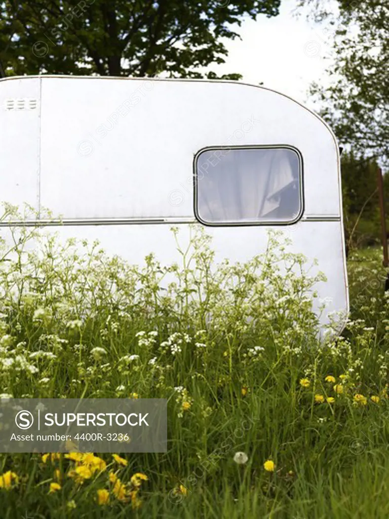 An old caravan in a field, Smaland, Sweden.