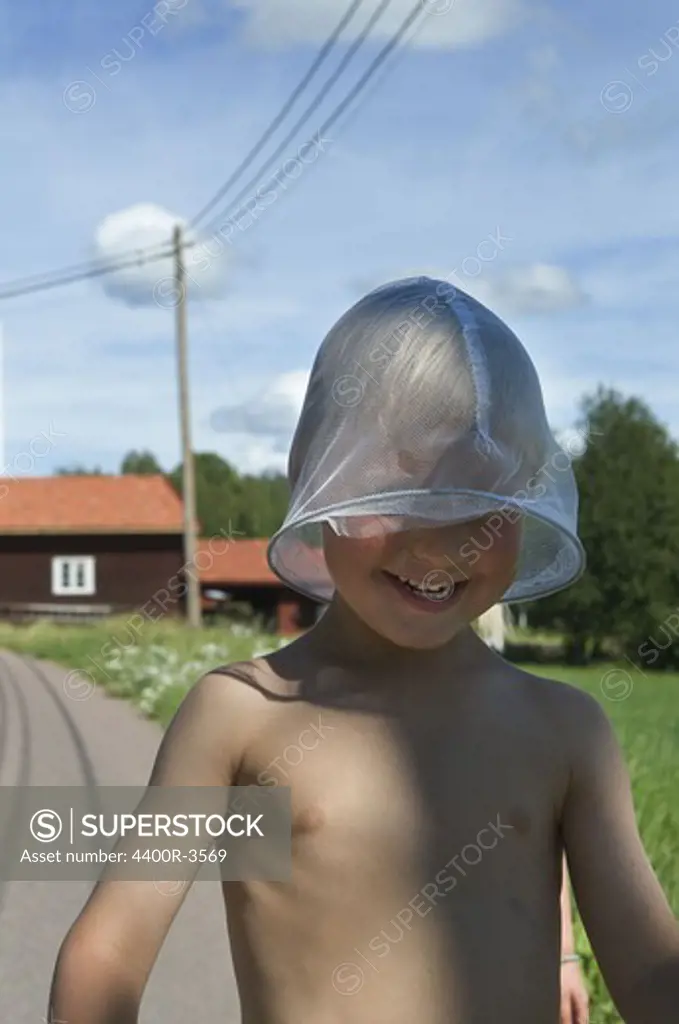 A boy playing with a butterfly-net, Dalarna, Sweden.