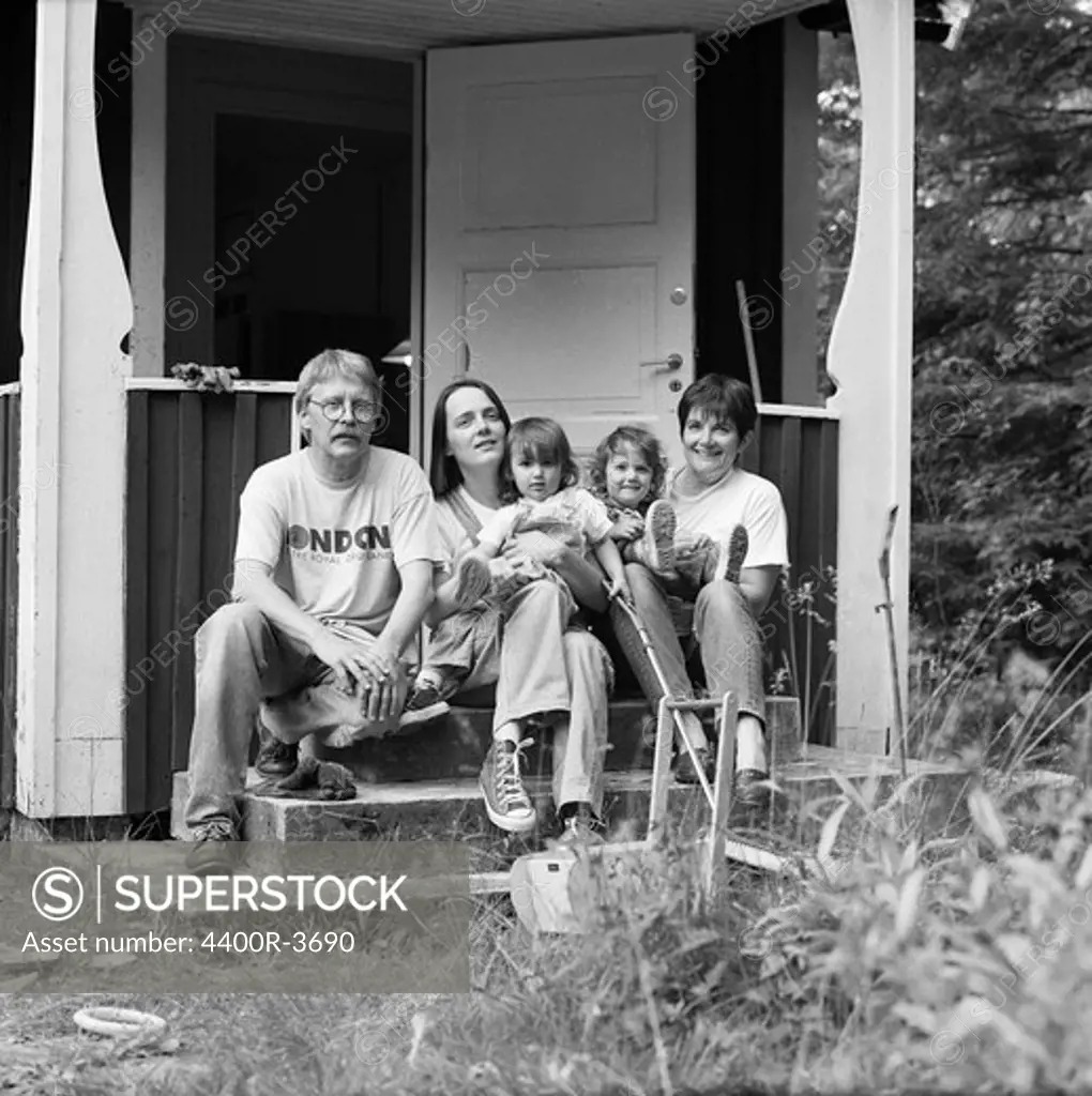 Family sitting on steps outside house