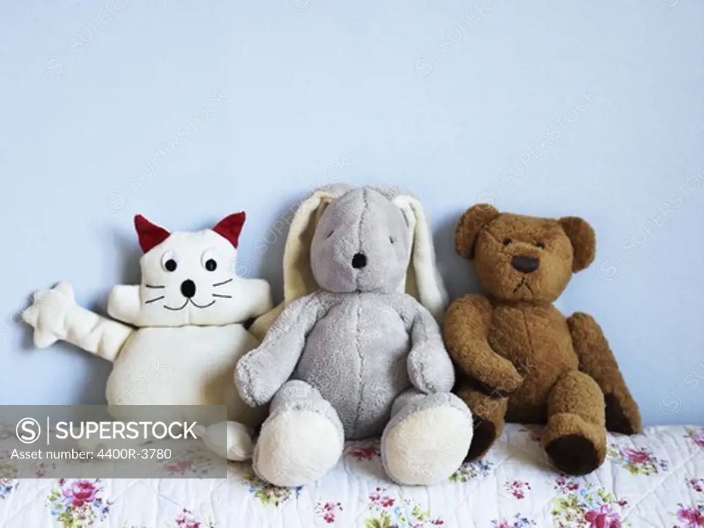 Three toy animals on a bed