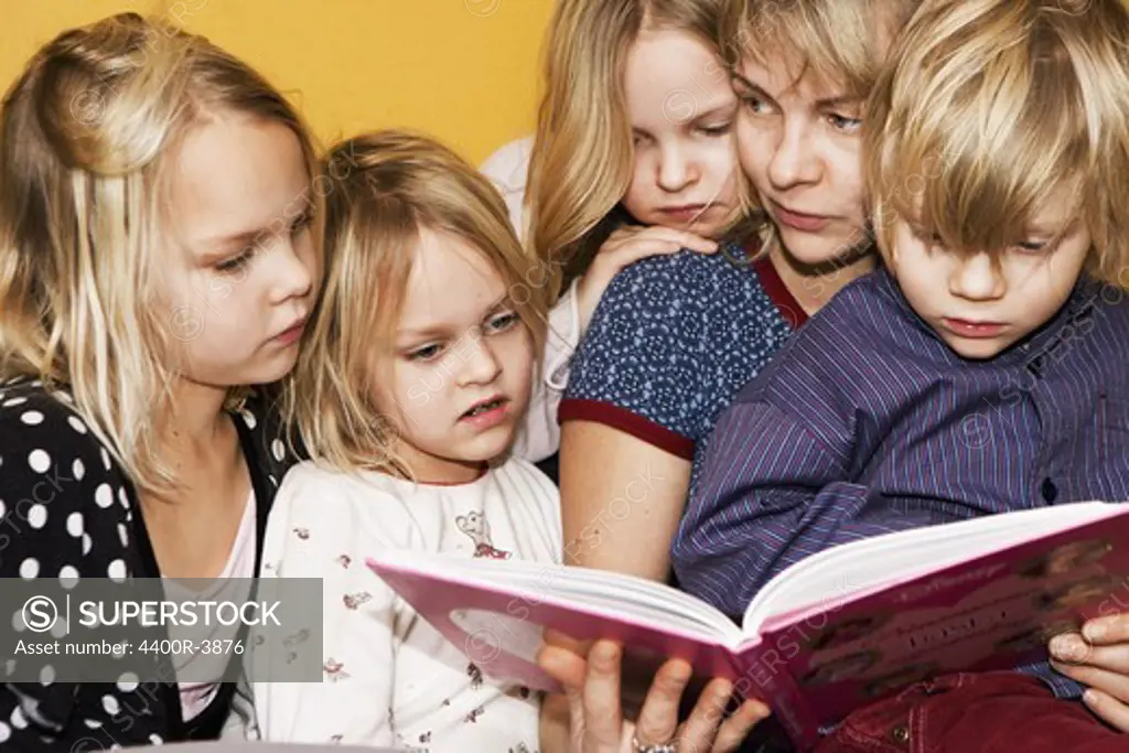Children reading a book, Sweden.