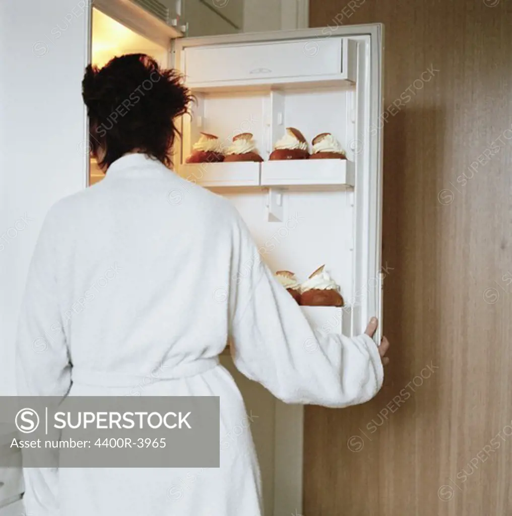 A woman opening a refrigerator