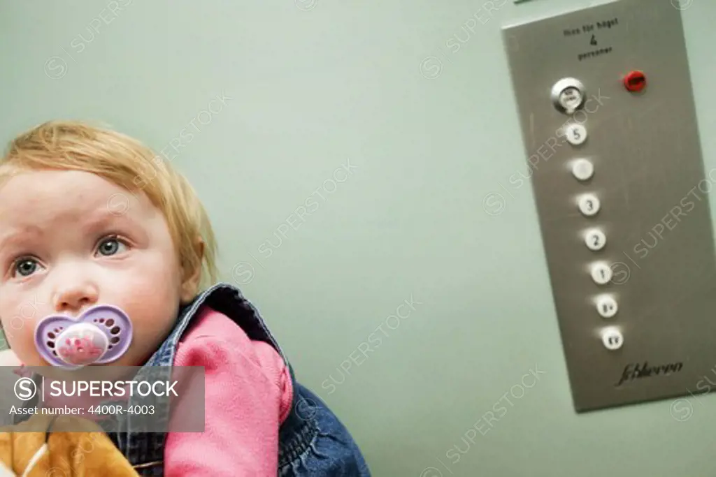 A sad baby girl in an elevator, Sweden.