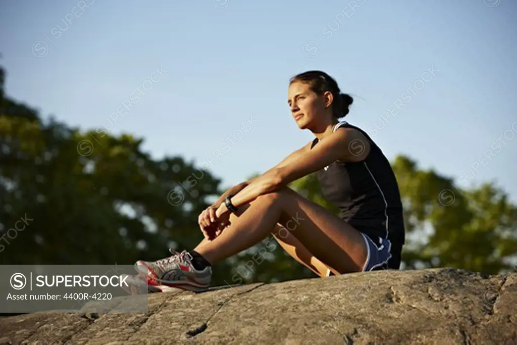 Young female runner relaxing, Sweden.