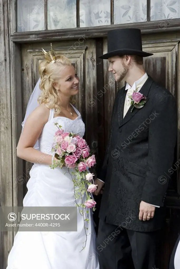 Bride and groom standing in front of wooden door