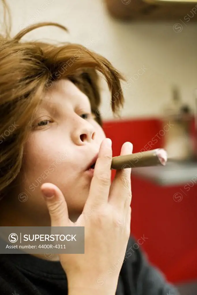Redhead boy pretending smoking cigar