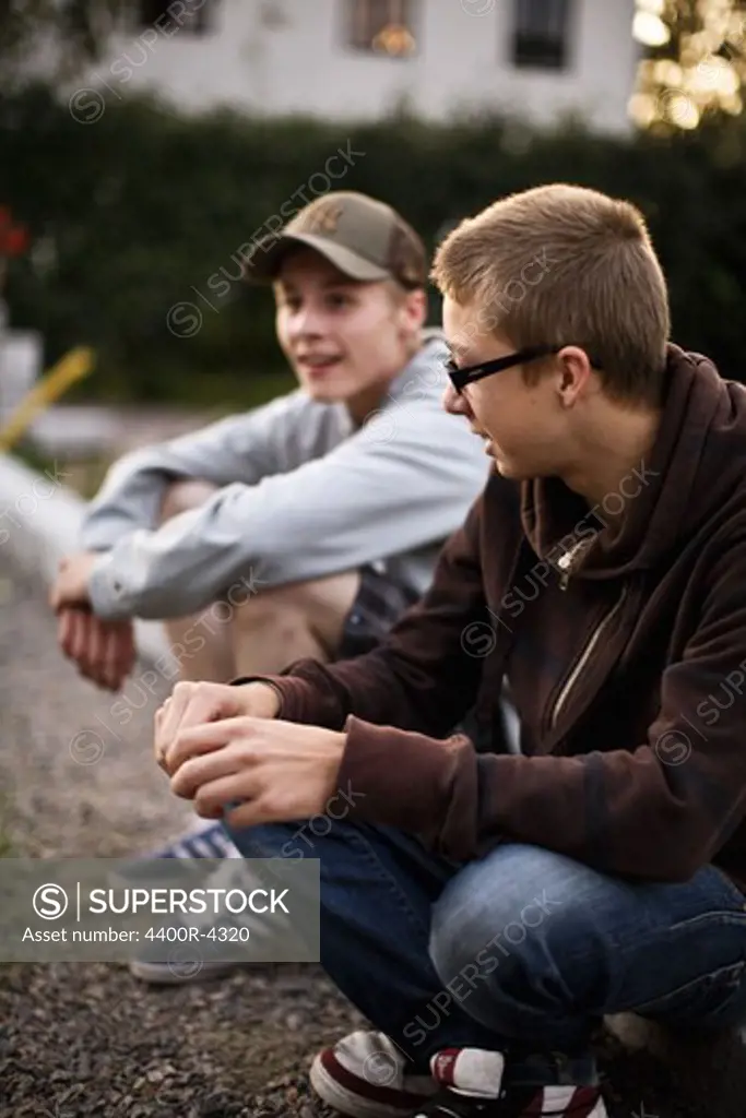 Teenagers sitting on curb