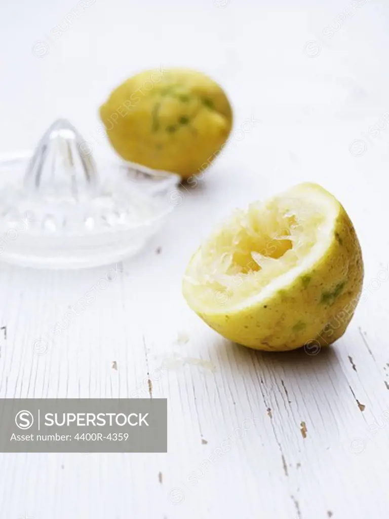 Scandinavia, Sweden, Lemon and squeezer on wooden background, close-up