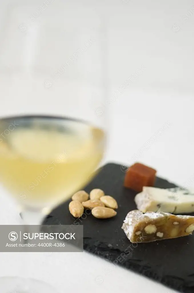 View of wine with assortment of cheese and almond in restaurant, close-up