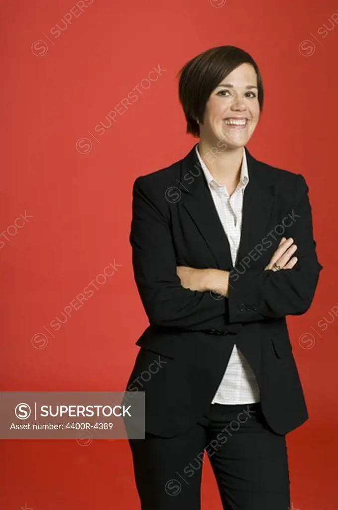 Female sommelier standing with arms crossed, smiling, portrait