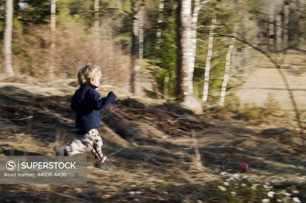Small boy running in forest