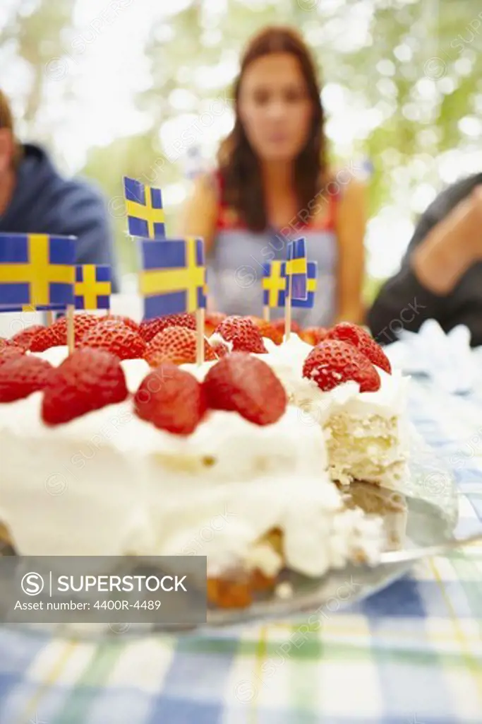 Strawberry cake with Swedish flag on table