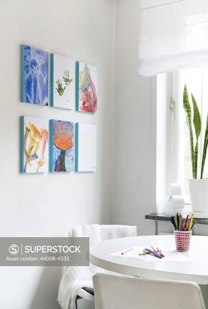 Paintings on wall near kitchen table