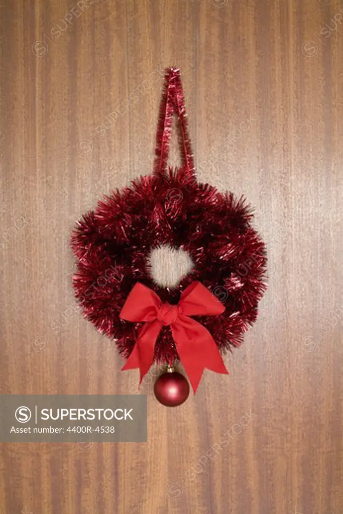 Wreath with bow hanging on wooden wall