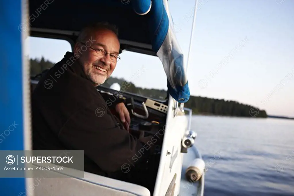 Man driving boat, smiling