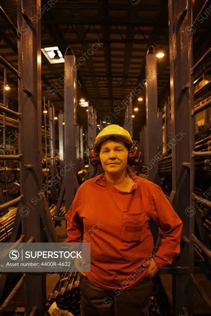 Woman wearing protective workwear standing in factory