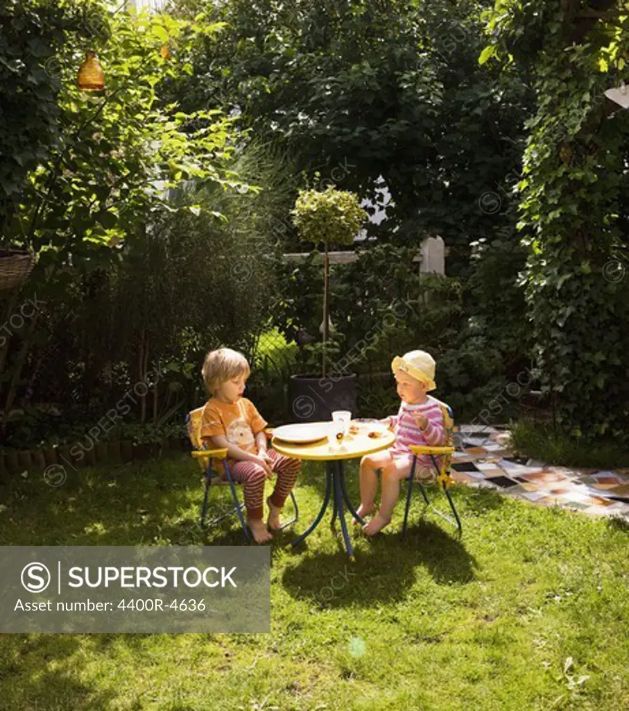 Boy and girl eating in garden