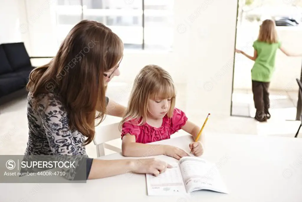 Woman helping daughter with homework