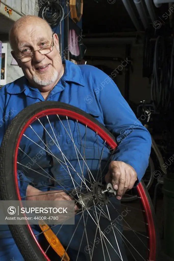 Senior man repairing tyre at repairing shop