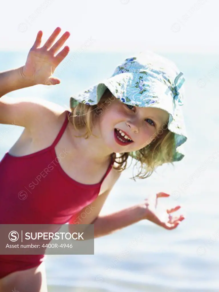 Portrait of small girl in red swimming suit and sun hat