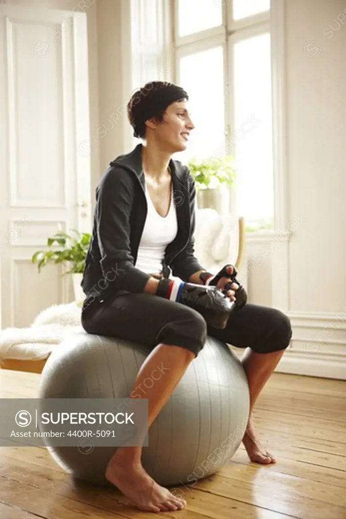 Smiling woman sitting on fitness ball