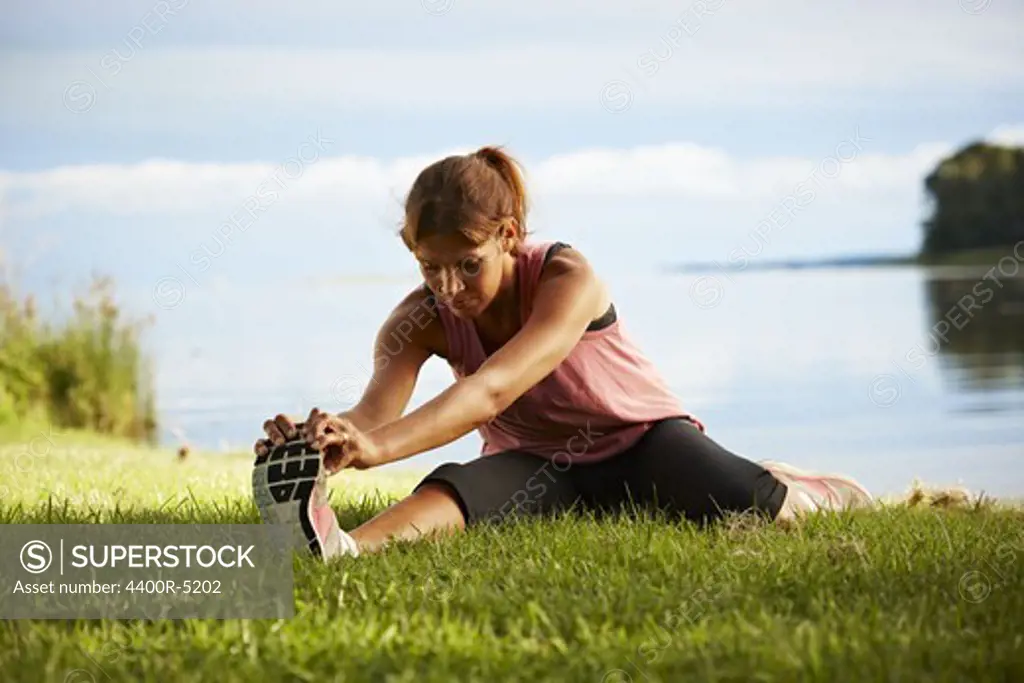 Woman stretching by lake