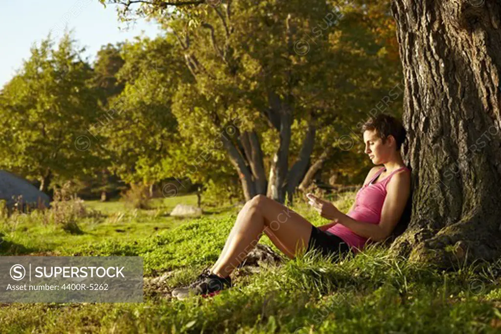 Young woman relaxing under tree