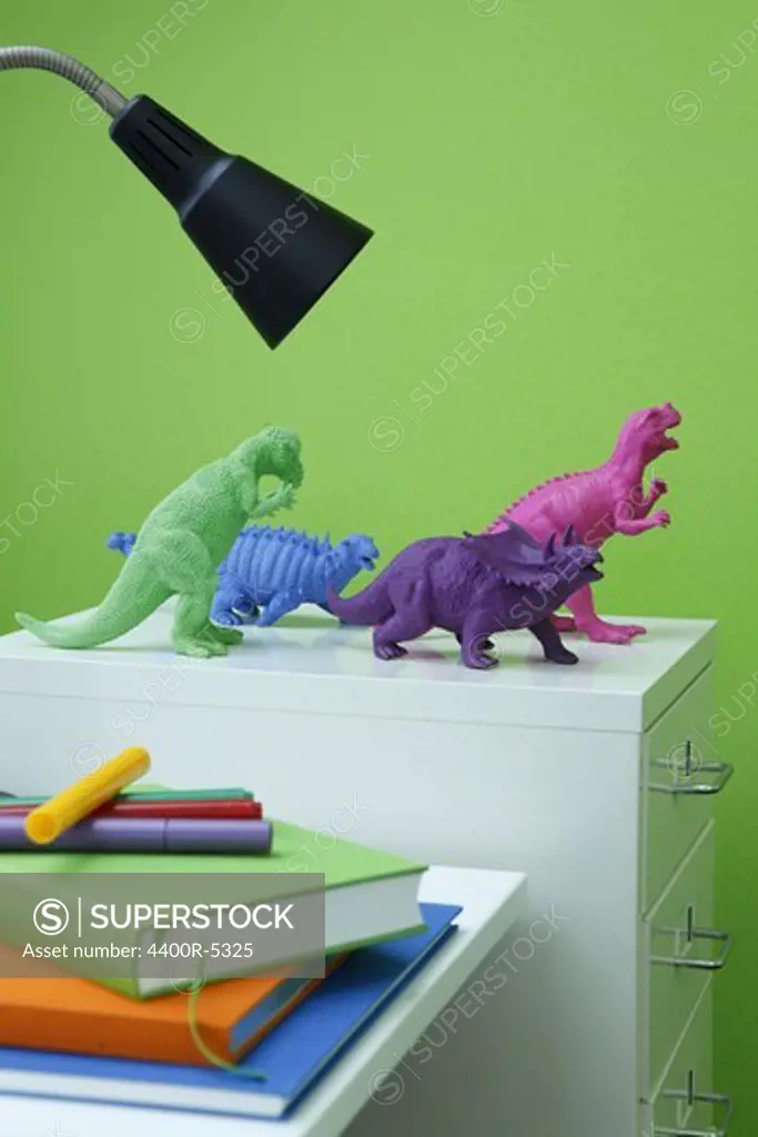 Colorful toy dinosaurs on cabinet