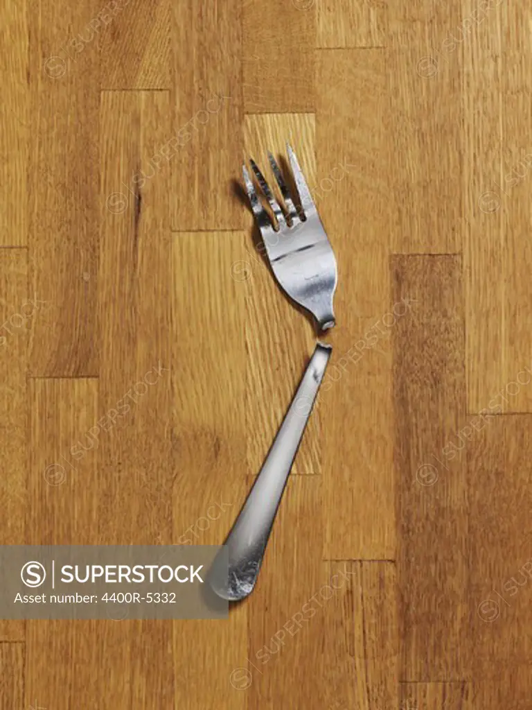 Close up of broken fork on parquet floor