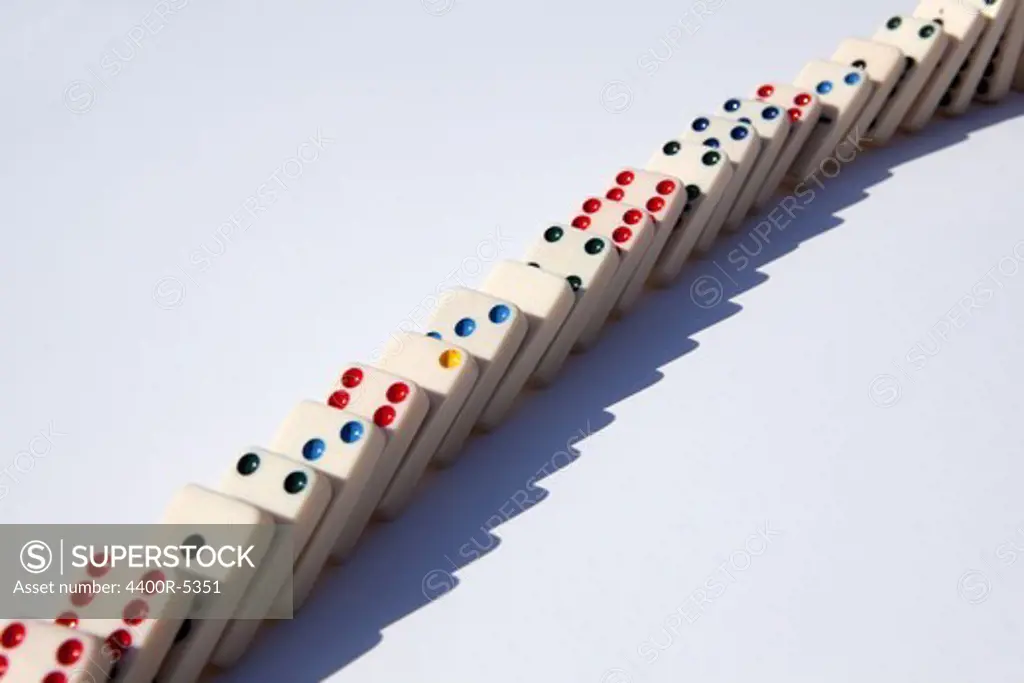 Close up of domino falling on white background, studio shot