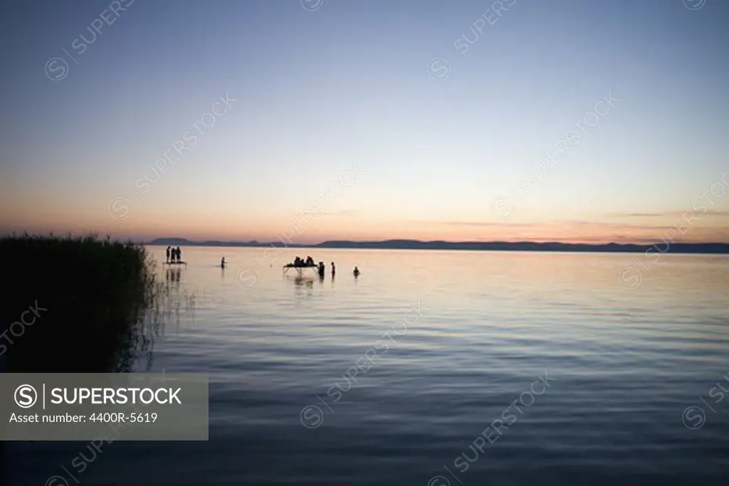 Silhouette of people bathing in a lake, Hungary.