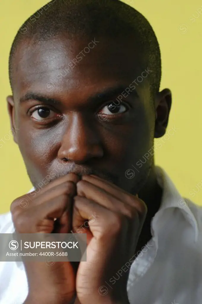 Portrait of a man against yellow background.