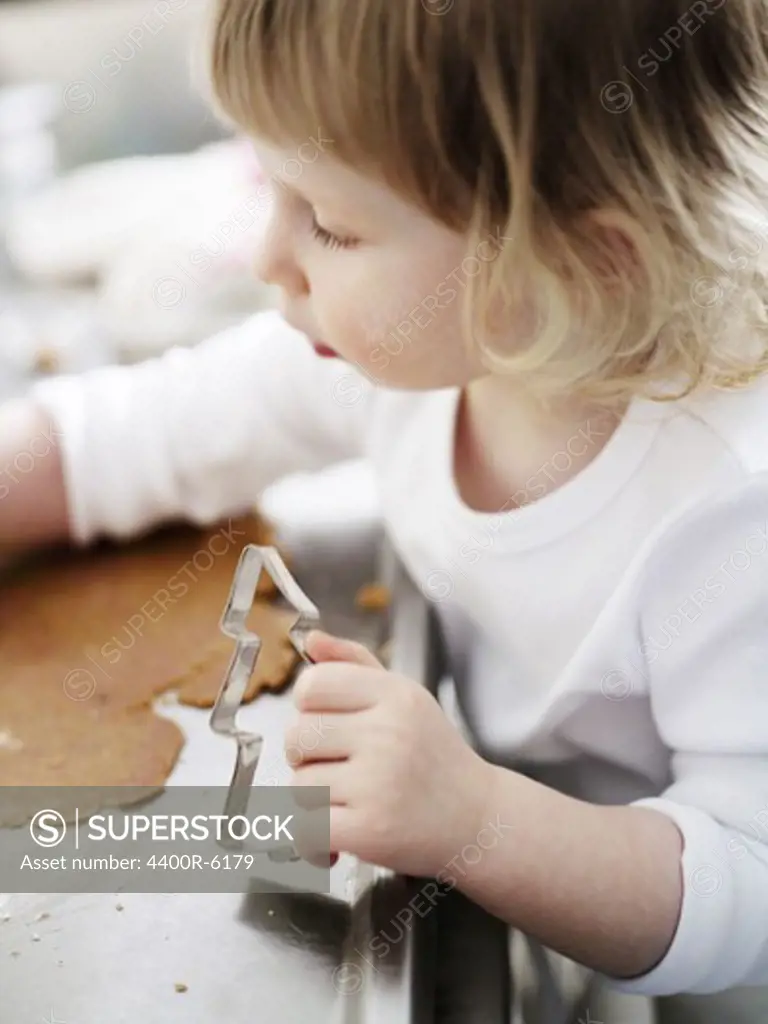 A little girl baking gingerbread, Sweden.