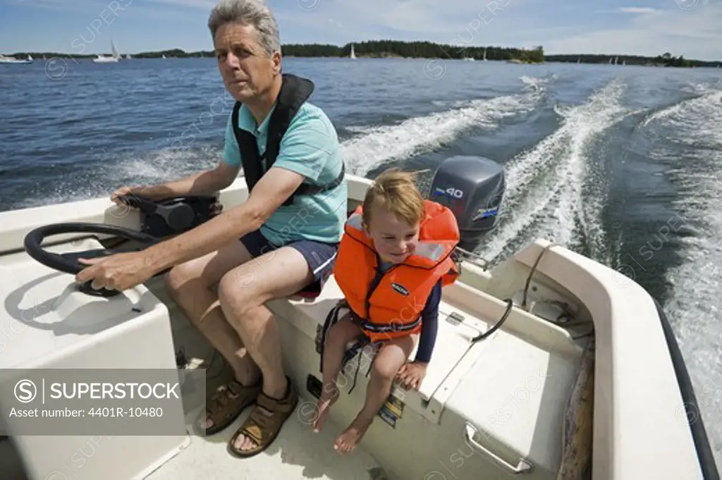 Grandfather and grandson in a boat, Stockholm archipelago, Sweden.